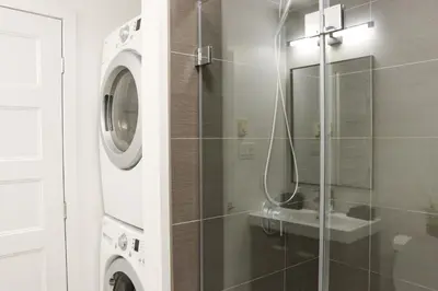 a bathroom with a sink and a washing machine at Luxury Artist Condo In Montreal in Montréal