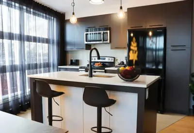 a kitchen with a sink and a counter with stools at Luxury Artist Condo In Montreal in Montréal