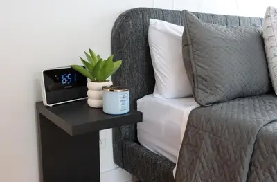 a bedroom with a bed and a table with a clock at Luxury Artist Condo In Montreal in Montréal