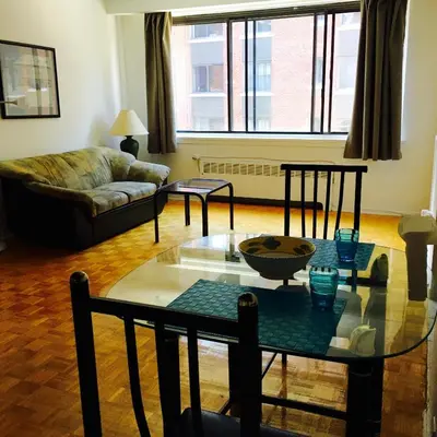 a living room with a glass table and a couch at Stylish Montreal Apartment Comfortable Stay in the Golden Square Mile in Montréal
