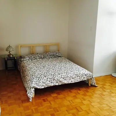 a bed in a room with a wooden floor at Stylish Montreal Apartment Comfortable Stay in the Golden Square Mile in Montréal