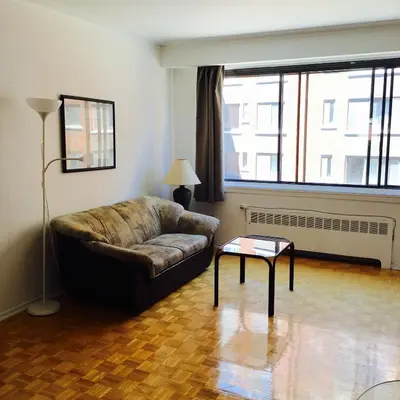a living room with a couch and a table at Stylish Montreal Apartment Comfortable Stay in the Golden Square Mile in Montréal