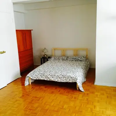 a bedroom with a bed and a wooden floor at Stylish Montreal Apartment Comfortable Stay in the Golden Square Mile in Montréal