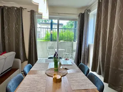 a living room with a wooden table and chairs at Modern 3BR 4beds apartment AC WiFi Free Parking in Laval