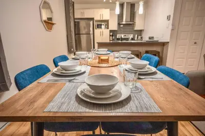 a wooden table with plates and dishes on it at Modern 3BR 4beds apartment AC WiFi Free Parking in Laval