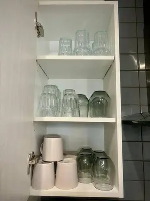 a cabinet filled with glass jars and cups at Modern 3BR 4beds apartment AC WiFi Free Parking in Laval