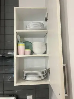 a cabinet filled with plates and bowls in a kitchen at Modern 3BR 4beds apartment AC WiFi Free Parking in Laval