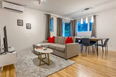 a living room with a couch and a table at Modern 3BR 4beds apartment AC WiFi Free Parking in Laval