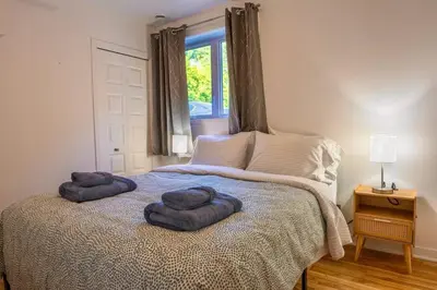 a bedroom with two pillows on a bed with a window at Modern 3BR 4beds apartment AC WiFi Free Parking in Laval
