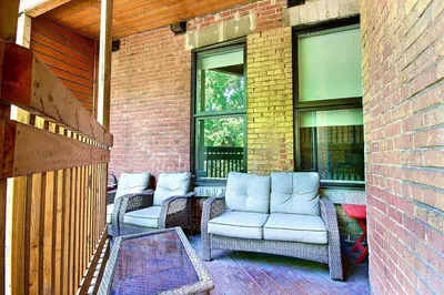 a patio with wicker chairs and windows on a brick building at Galeria St Denis in Prime Montreal in Montréal