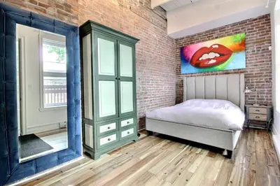 a bedroom with a bed and a brick wall at Galeria St Denis in Prime Montreal in Montréal