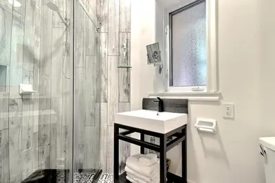 a white bathroom with a sink and a shower at Galeria St Denis in Prime Montreal in Montréal