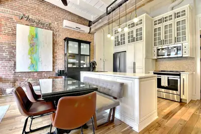 a kitchen with a dining table and a brick wall at Galeria St Denis in Prime Montreal in Montréal