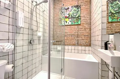 a bathroom with a shower and a tub and a sink at Galeria St Denis in Prime Montreal in Montréal