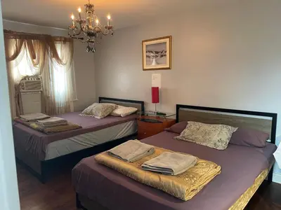 a bedroom with two beds and a chandelier at Self service small breakfast, 2 double beds private room in Montréal