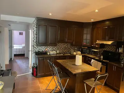 a kitchen with wooden cabinets and a counter top at Self service small breakfast, 2 double beds private room in Montréal