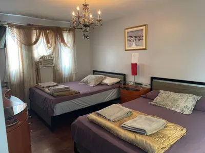 a bedroom with two beds and a chandelier at Self service small breakfast, 2 double beds private room in Montréal