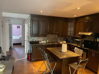 a kitchen with wooden cabinets and a table with chairs at Self service small breakfast, 2 double beds private room in Montréal