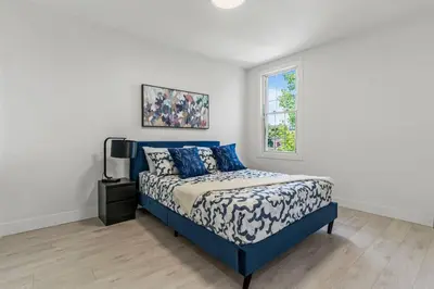 a bedroom with a blue bed and a window at Appartement haut de gamme NDG in Montréal