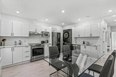 a kitchen with a glass table and white cabinets at Appartement haut de gamme NDG in Montréal