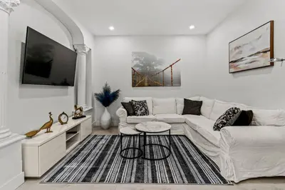 a living room with a white couch and a tv at Appartement haut de gamme NDG in Montréal