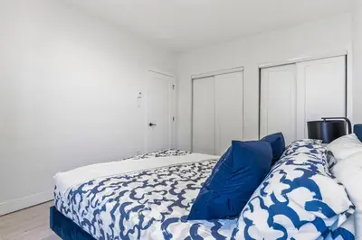 a bedroom with a bed with blue pillows at Appartement haut de gamme NDG in Montréal