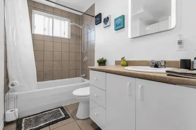 a bathroom with a toilet and a sink and a tub at Cozy 3 Bedrooms Montreal in Montréal