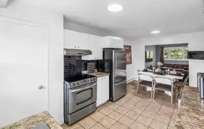 a kitchen with stainless steel appliances and a table at Cozy 3 Bedrooms Montreal in Montréal