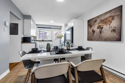 a dining room with a white table and chairs at Cozy 3 Bedrooms Montreal in Montréal