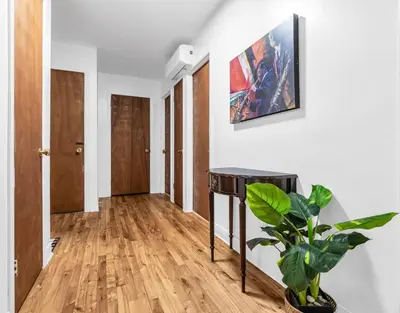 a hallway with a potted plant and a painting on the wall at Cozy 3 Bedrooms Montreal in Montréal