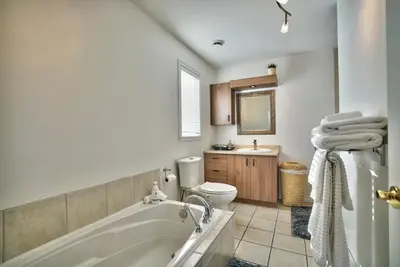 a bathroom with a tub and a toilet and a sink at Dynamite 2-Bedroom House, Garage, Sleeps 6 in Sherbrooke