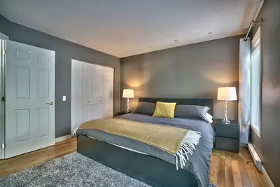 a bedroom with a large bed and two lamps at Dynamite 2-Bedroom House, Garage, Sleeps 6 in Sherbrooke