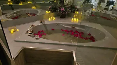 a bathroom with a tub with pink flowers in it at Hotel Oasis Lac St-Louis in Salaberry de Valleyfield