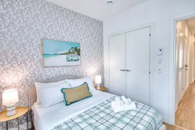 a bedroom with a bed and two tables with lamps at Beautiful & New! Renovated for your Style Comfort in Montréal