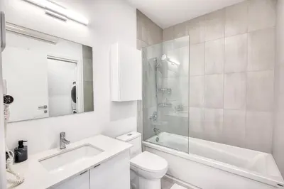 a white bathroom with a sink and a toilet at Beautiful & New! Renovated for your Style Comfort in Montréal
