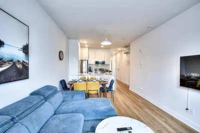 a living room with a blue couch and a table at Beautiful & New! Renovated for your Style Comfort in Montréal