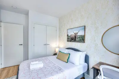 a bedroom with a bed and a picture of a cow on the wall at Beautiful & New! Renovated for your Style Comfort in Montréal