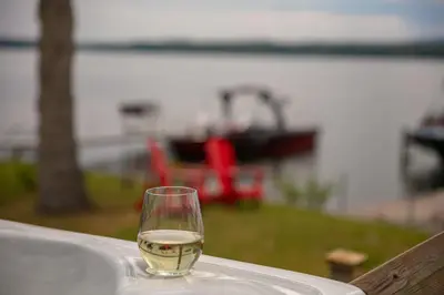 a glass of wine sitting on top of a table at La Cozy O-Lac Magog in Sherbrooke