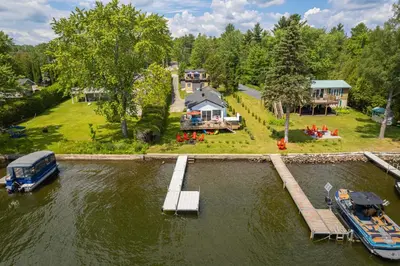 an aerial view of a house on the water with a dock at La Cozy O-Lac Magog in Sherbrooke