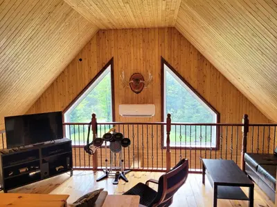 a room with large windows in a wooden cabin at Spa Nature Estrie in Saint-Herménégilde