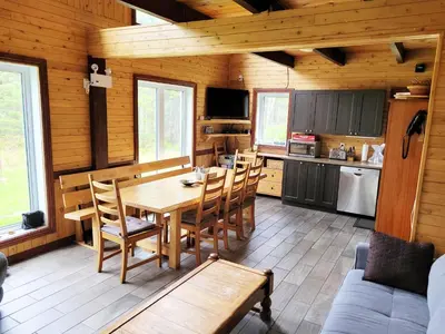 a kitchen and dining room with a table and chairs at Spa Nature Estrie in Saint-Herménégilde