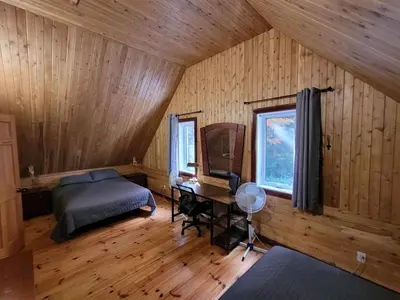 a bedroom with a bed and a desk and a mirror at Spa Nature Estrie in Saint-Herménégilde