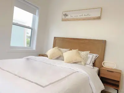 a bedroom with a bed with white sheets and a window at 10 minutes to DT with Free parking in Longueuil