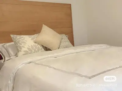 a white bed with a wooden headboard and pillows at 10 minutes to DT with Free parking in Longueuil