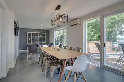 a dining room with a wooden table and chairs at La vie O-Lac Magog in Sherbrooke