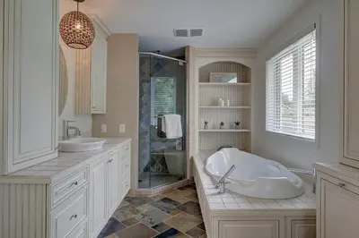 a white bathroom with two sinks and a shower at La vie O-Lac Magog in Sherbrooke