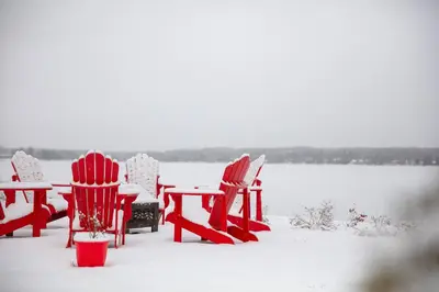 a group of chairs and tables covered in snow at La vie O-Lac Magog in Sherbrooke