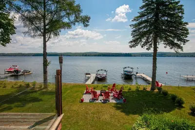 two boats are docked at a dock on a lake at La vie O-Lac Magog in Sherbrooke