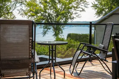 a table and two chairs on a deck with a view at La Vue O-Lac Magog in Sherbrooke