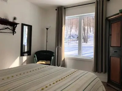 a bedroom with a bed and a window at Rooms in peaceful nature settings in Sutton